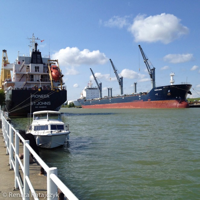 International cargo ships and small motor boat parked in Oshawa's Pier area. Ontario, Canada